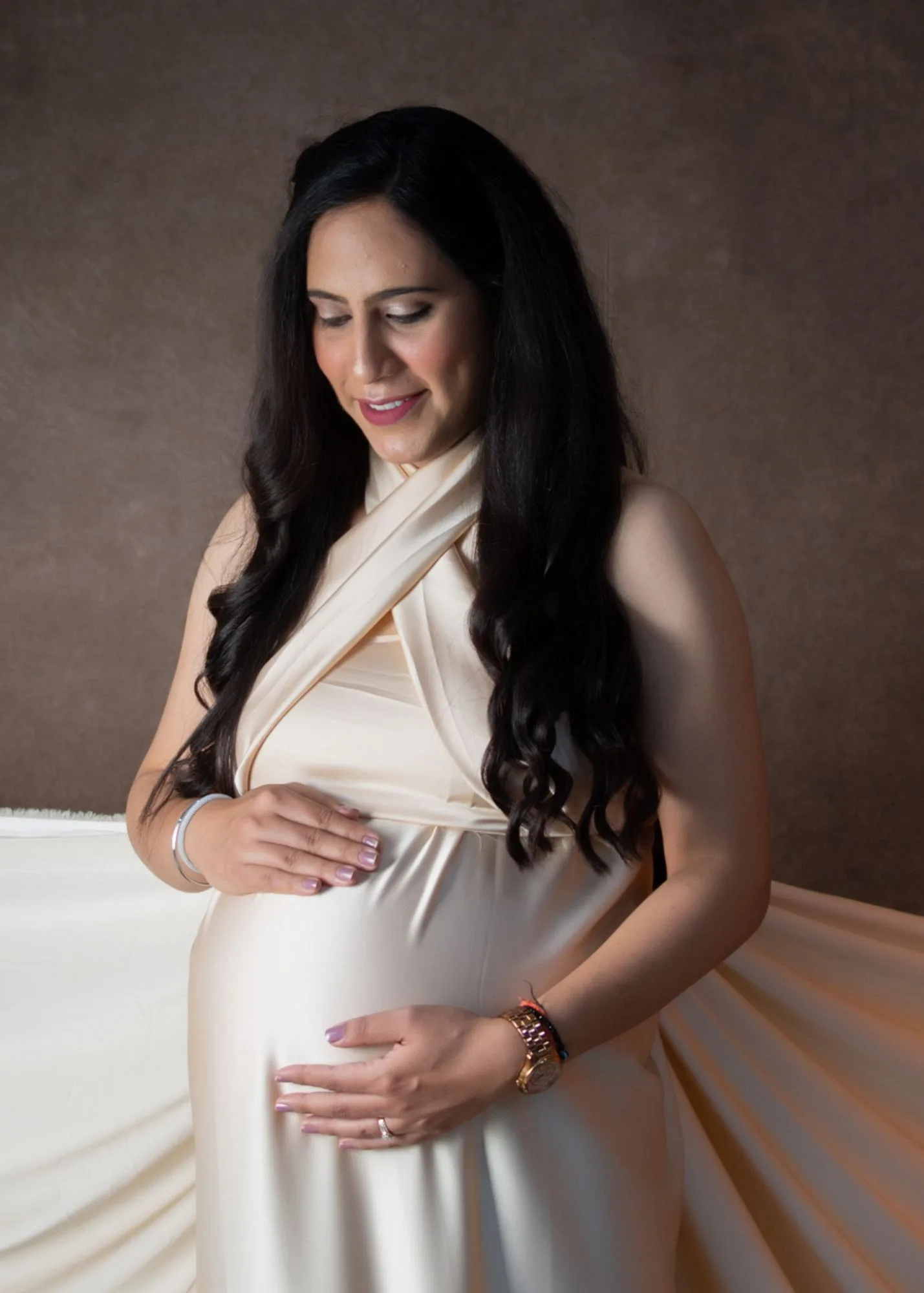 Close-up portrait of expectant mother in a detailed cream dress