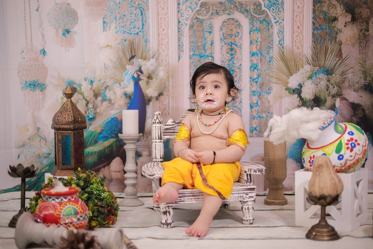 Baby boy as Krishna with a playful expression and butter on his face, Janmashtami Krishna theme baby photoshoot in Delhi NCR.