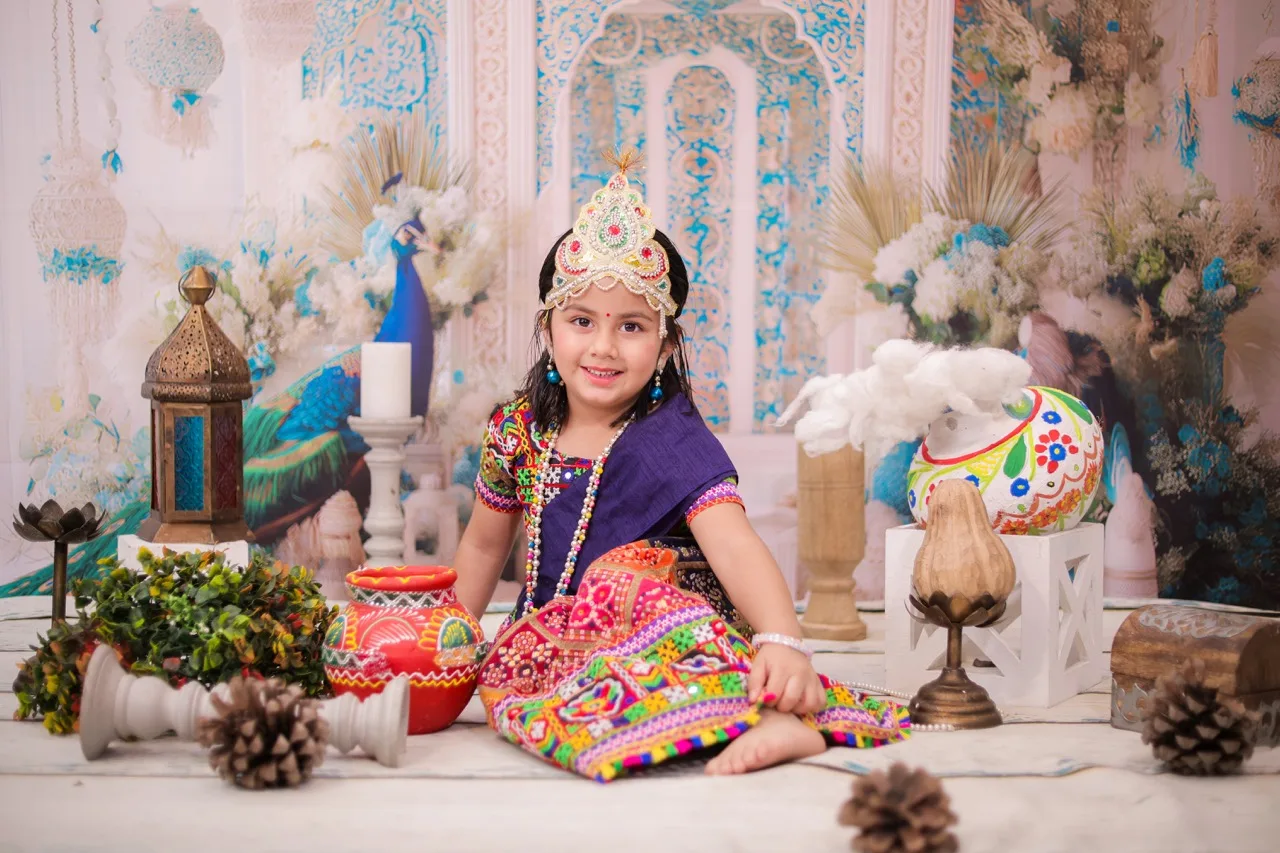Little girl smiling brightly in a Radha costume for a studio photoshoot, Janmashtami Krishna theme baby photoshoot in Delhi NCR.
