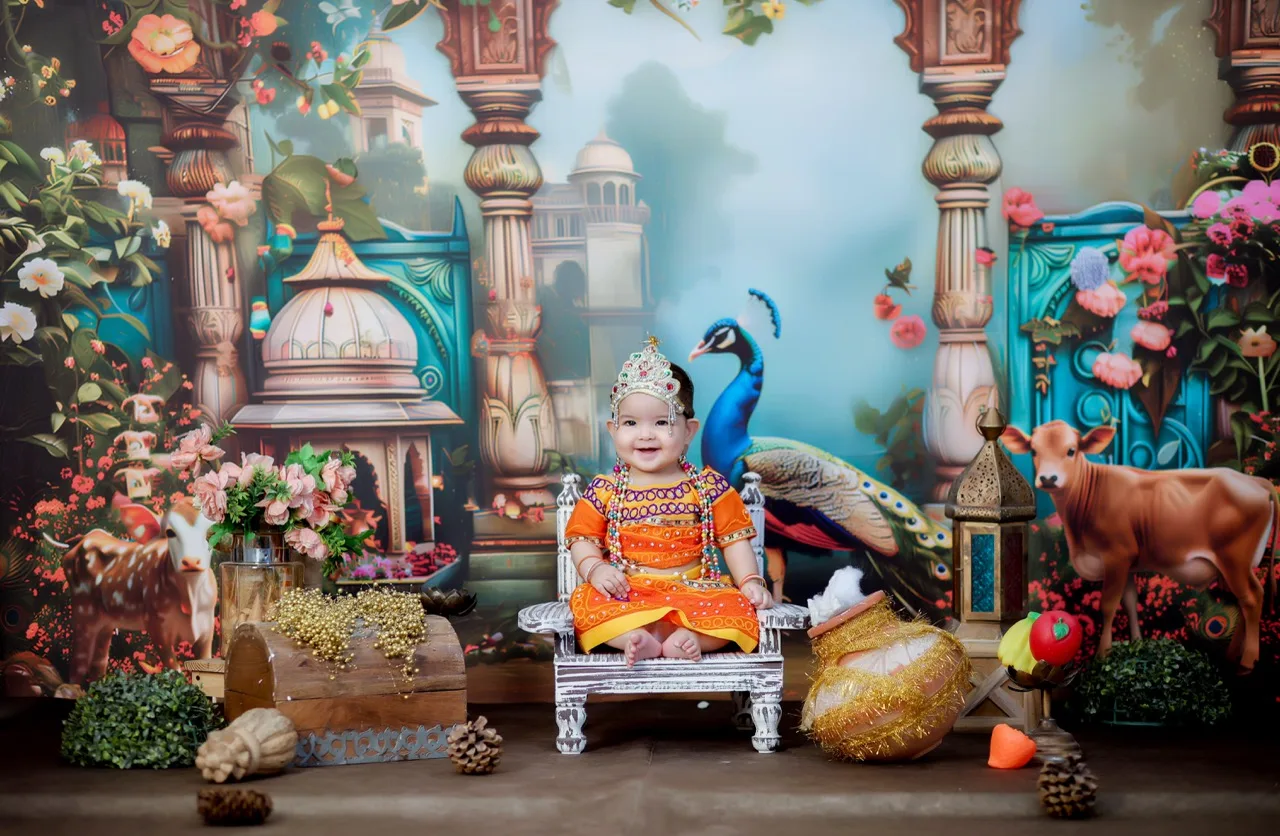 Baby girl in Radha dress sitting in a Gokul theme with peacocks and cows, Janmashtami Krishna theme baby photoshoot in Delhi NCR.