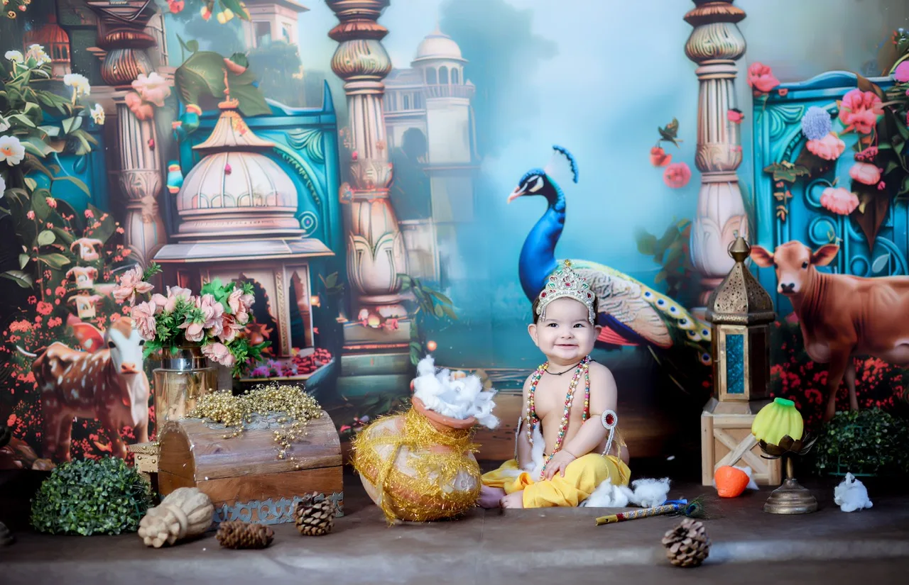 An adorable baby sitting playfully in a Gokul setting with a pot of butter, Janmashtami Krishna theme baby photoshoot in Delhi NCR.