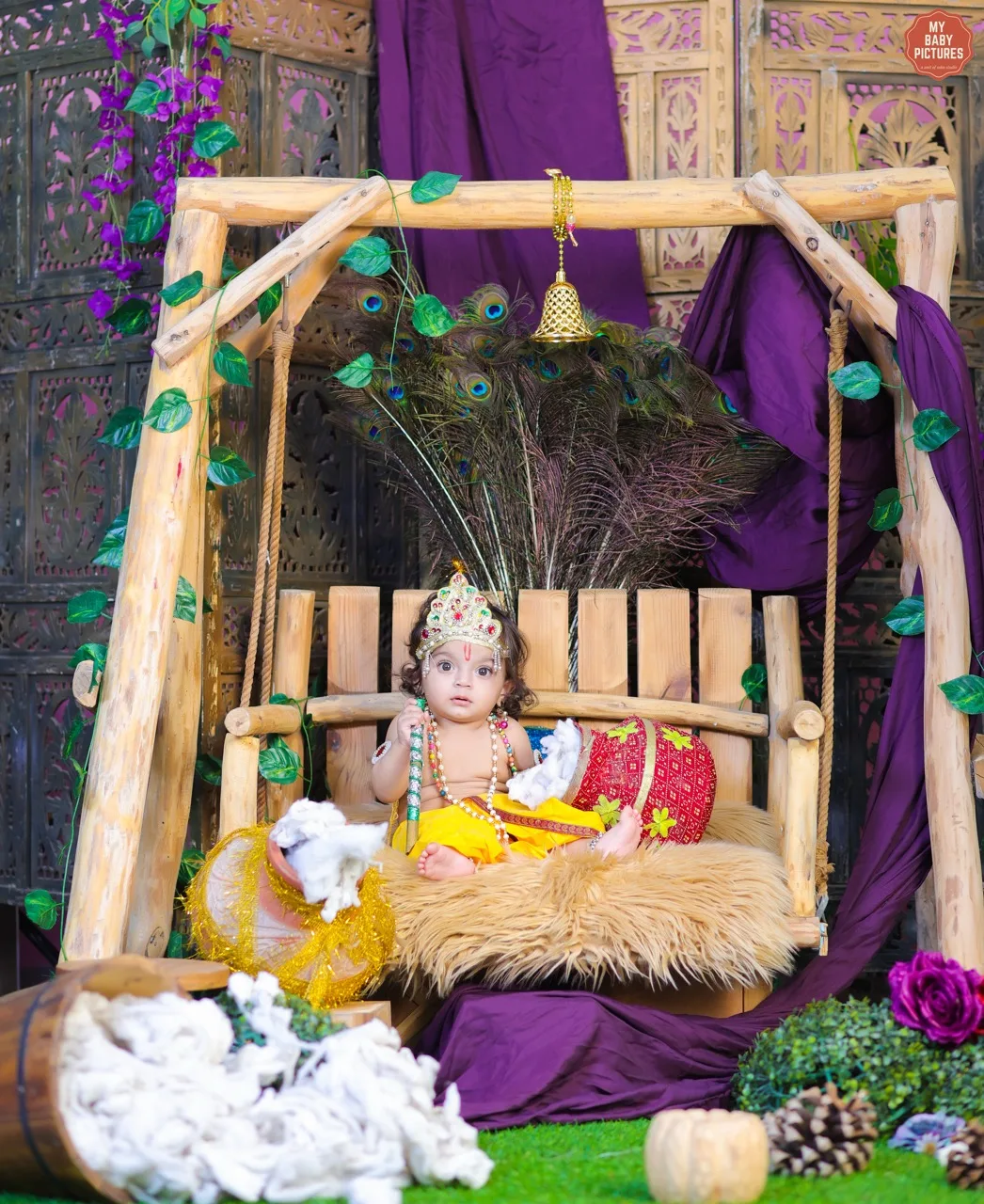 Baby boy with a crown as Krishna sitting with a butter pot on a jhula, Janmashtami Krishna theme baby photoshoot in Delhi NCR.