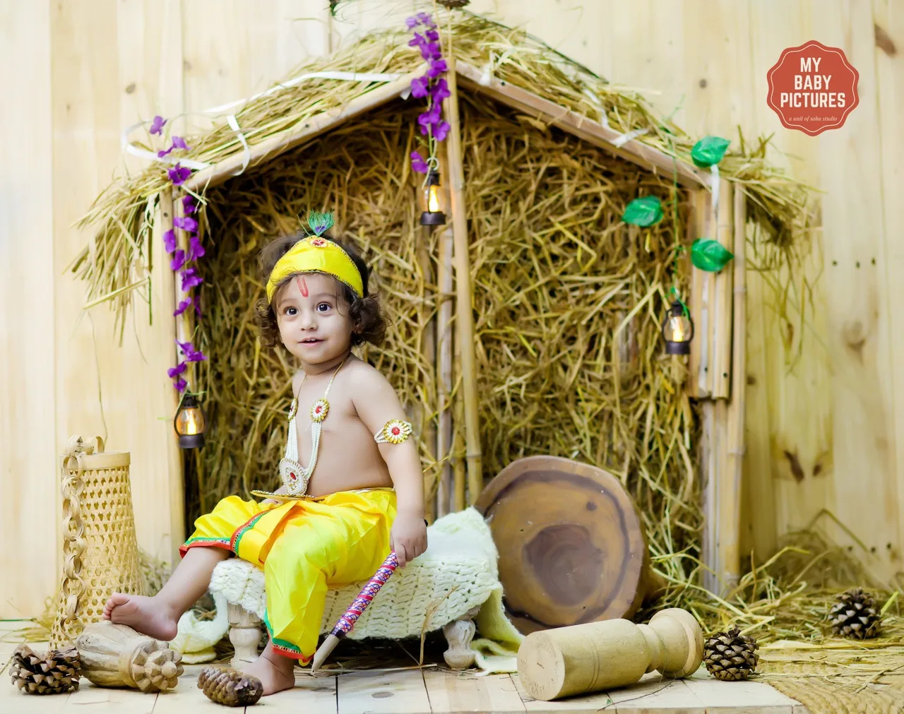 Toddler boy in Krishna costume holding a flute in a Kutiya theme, Janmashtami Krishna theme baby photoshoot in Delhi NCR.