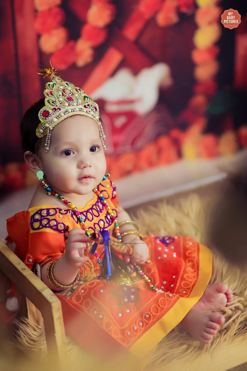 Baby photoshoot with a beautiful Vrindavan background and marigold flowers, Janmashtami Krishna theme baby photoshoot in Delhi NCR.