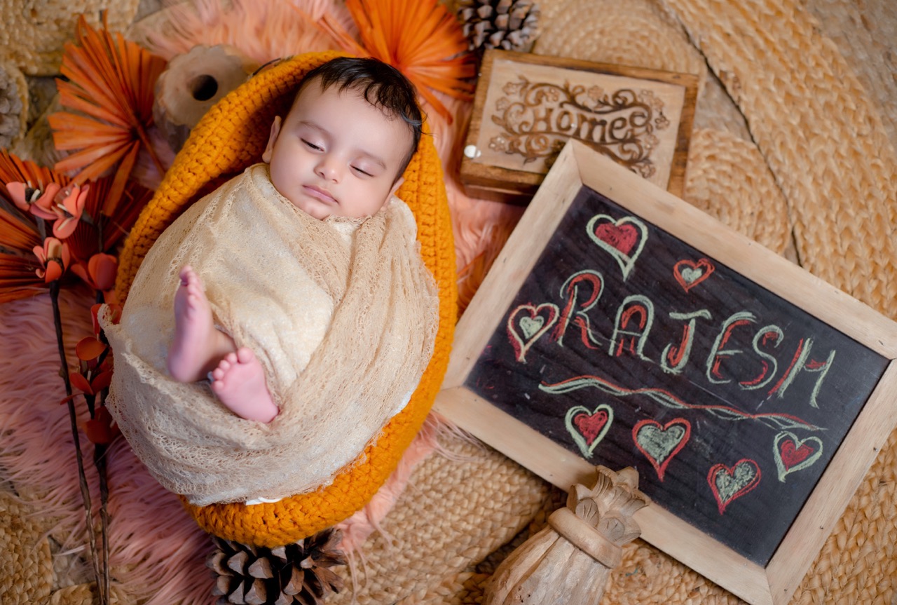 Wrapped newborn portrait with name board